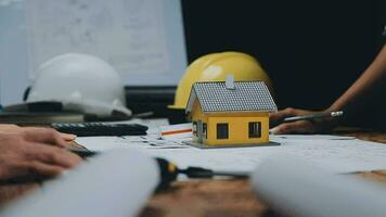 Image of team engineer checks construction blueprints on new project with engineering tools at desk in office. video