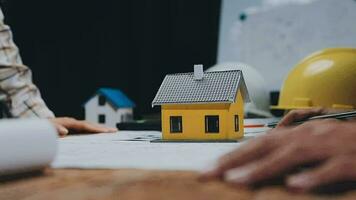 Image of team engineer checks construction blueprints on new project with engineering tools at desk in office. video