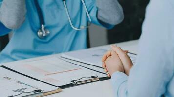 femme patient visite femelle médecin à clinique bureau. médical travail écrit une ordonnance sur une table dans une hôpital. video