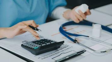 Woman patient visiting female doctor at clinic office. Medical work writes a prescription on a table in a hospital. video