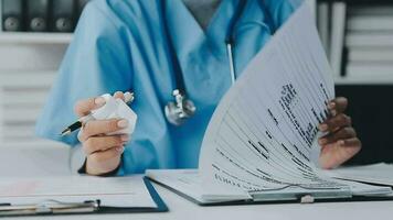 Woman patient visiting female doctor at clinic office. Medical work writes a prescription on a table in a hospital. video