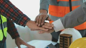 costruzione e struttura concetto di ingegnere o architetto incontro per progetto Lavorando con compagno e ingegneria utensili su modello edificio e planimetria nel Lavorando luogo, contrarre per tutti e due aziende. video