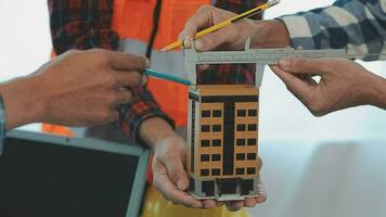 costruzione e struttura concetto di ingegnere o architetto incontro per progetto Lavorando con compagno e ingegneria utensili su modello edificio e planimetria nel Lavorando luogo, contrarre per tutti e due aziende. video