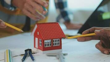 costruzione e struttura concetto di ingegnere o architetto incontro per progetto Lavorando con compagno e ingegneria utensili su modello edificio e planimetria nel Lavorando luogo, contrarre per tutti e due aziende. video