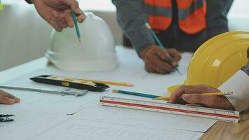 costruzione e struttura concetto di ingegnere o architetto incontro per progetto Lavorando con compagno e ingegneria utensili su modello edificio e planimetria nel Lavorando luogo, contrarre per tutti e due aziende. video