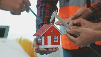 costruzione e struttura concetto di ingegnere o architetto incontro per progetto Lavorando con compagno e ingegneria utensili su modello edificio e planimetria nel Lavorando luogo, contrarre per tutti e due aziende. video