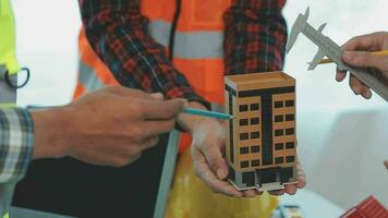 costruzione e struttura concetto di ingegnere o architetto incontro per progetto Lavorando con compagno e ingegneria utensili su modello edificio e planimetria nel Lavorando luogo, contrarre per tutti e due aziende. video