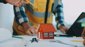 costruzione e struttura concetto di ingegnere Lavorando disegno su planimetria incontro per progetto Lavorando con compagno su modello edificio e ingegneria utensili nel Lavorando luogo, costruzione concetto. video