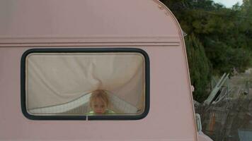 A girl is looking out of the window in a van video