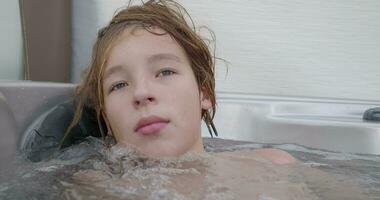 uma adolescente é sentado dentro uma quente banheira video