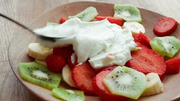 Fruit salad with greek yogurt on a plate video