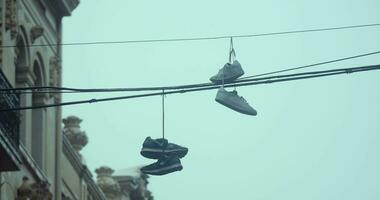 Sneakers hanging on electric wires in rainy weather video