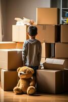 Single child looking down hugging teddy bear amidst moving boxes photo