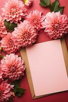 Top view of pink dahlia and red fuchsia flowers in envelope with paper card note on pink background photo