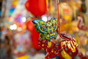 Decorated colorful lanterns hanging on a stand in the streets in Ho Chi Minh City, Vietnam during Mid Autumn Festival. Chinese language in photos mean money and happiness. Selective focus.