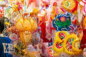 Decorated colorful lanterns hanging on a stand in the streets in Ho Chi Minh City, Vietnam during Mid Autumn Festival. Chinese language in photos mean money and happiness. Selective focus.