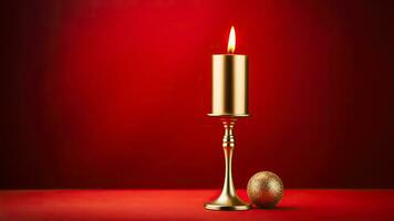 Golden mid-century candle holder with a glowing flame enhancing Christmas nostalgia isolated on a festive red gradient background photo