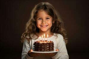 a girl holding a birthday cake with several candles on bokeh style background photo