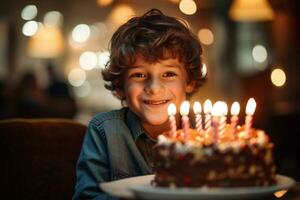 a boy holding a birthday cake with several candles on bokeh style background photo