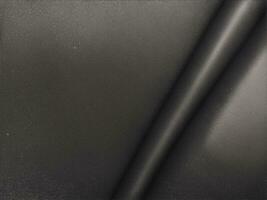 Black abstract background. Beautiful folds on shiny fabric or leather. Silk satin texture background for design. Elegant silver background. photo