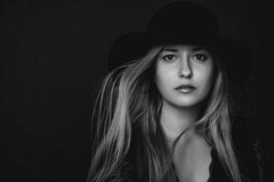 Beautiful blonde woman wearing a hat, artistic film portrait in black and white for fashion campaign and beauty brand photo