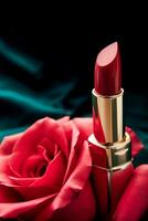 Red lipstick in a golden tube and blooming rose flower, beauty cosmetic and make-up product, generative ai photo