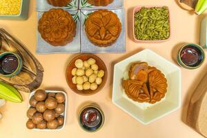 a tasty round moon cakes at mid autumn festival. Flat lay mid autumn festival food and drink on sweet beige background. photo