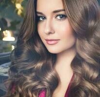 Beautiful woman with curly volume hairstyle, long luxurious hair and beauty make-up, glamorous look face portrait for luxury fashion and natural cosmetics photo