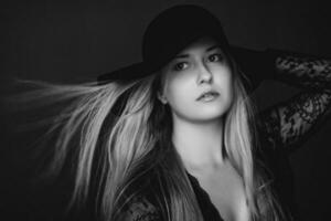 Beautiful blonde woman wearing a hat, artistic film portrait in black and white for fashion campaign and beauty brand photo