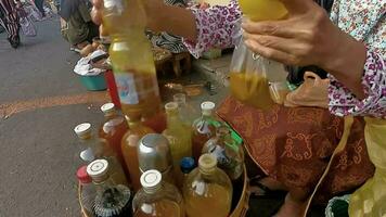 Jamu gendong or herbs drinks brewing her drink in a glass or plastic for customer. Jamu is a traditional herbs drinks for health from javanese , Indonesia. video