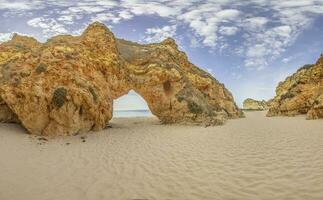 Panoramic picture between the cliffs at Praia do Prainha on the Portuguese Algarve coast during the day photo