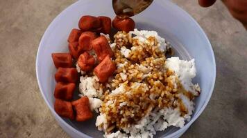 The traditional way of eating fried sausage and rice is topped with sweet soy sauce video