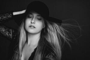 Beautiful blonde woman wearing a hat, artistic film portrait in black and white for fashion campaign and beauty brand photo