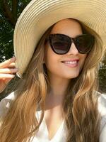 belleza, verano fiesta y moda, cara retrato de contento mujer vistiendo sombrero y Gafas de sol, para protección de la piel productos cosméticos, protector solar spf estilo de vida Mira foto