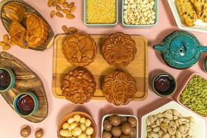 a tasty round moon cakes at mid autumn festival. Flat lay mid autumn festival food and drink on sweet pink background. photo