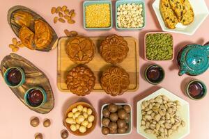 a tasty round moon cakes at mid autumn festival. Flat lay mid autumn festival food and drink on sweet pink background. photo