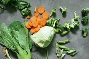 Cuts of various fresh ready to cook vegetables on a concrete background photo