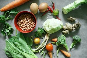 Cuts of various fresh ready to cook vegetables on a concrete background photo