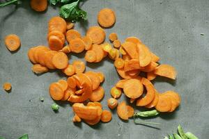 Fresh carrot vegetable pieces on concrete background photo