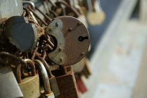 Many Rusty Padlocks Closed on Bridge Fence - Love Concept photo