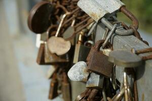 Many Rusty Padlocks Closed on Bridge Fence - Love Concept photo