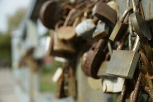 Many Rusty Padlocks Closed on Bridge Fence - Love Concept photo