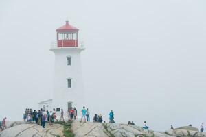 de peggy ensenada, Canadá - agosto 13, 2015-personas cerca el de peggy ensenada faro en estrella nueva Escocia-Canadá durante un brumoso día foto