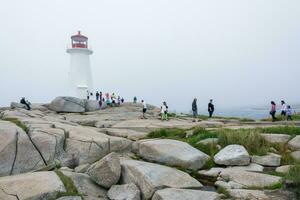 de peggy ensenada, Canadá - agosto 13, 2015-personas cerca el de peggy ensenada faro en estrella nueva Escocia-Canadá durante un brumoso día foto