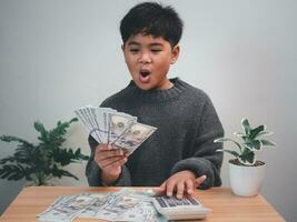 The boy joyfully holds the money. Concept of commerce , finance, accounting, money saving , investment. photo