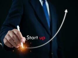Businessman presses the pen at the starting point to start a business. Startup concept. Business concept. photo