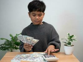 The boy joyfully holds the money. Concept of commerce , finance, accounting, money saving , investment. photo