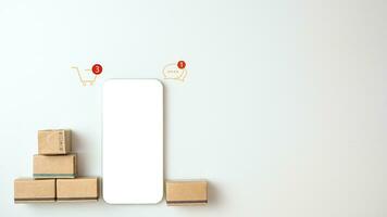 Shopping concept. Cardboard box and phone with blank screen on white background. Online shopping consumers can choose from home shopping and delivery services. with copy space. photo