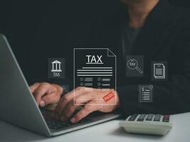 Businessman using a computer to complete Individual income tax return form online for tax payment. financial research, report. Calculation tax return. photo