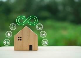 Model wooden house with green recycle symbol on nature background. Recycling concept. environmental protection concept photo